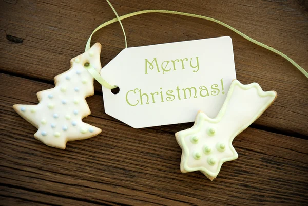 Saludos de Navidad en una etiqueta con galletas de Navidad — Foto de Stock