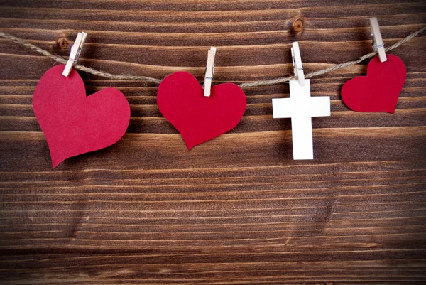 Colorful Hearts and a Cross Hanging on Wooden Background — Stock Photo, Image