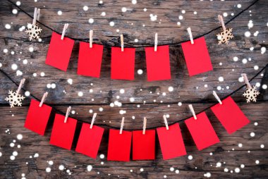Red Tags with Copy Space Hanging in the Snow on Wooden Background clipart
