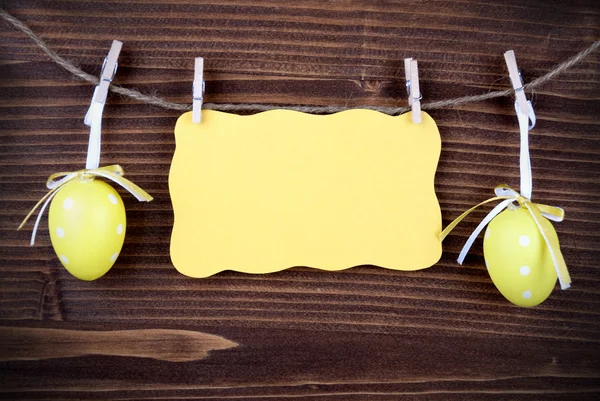 Желтая этикетка с двумя пасхальными яйцами и копировальным пространством и рамкой — стоковое фото
