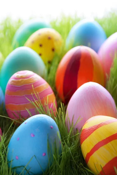 Vele kleurrijke Pasen eieren op zonnige groen gras — Stockfoto