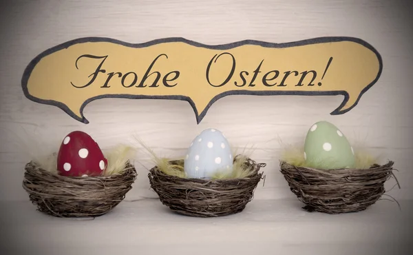 Reflektor do trzy kolorowe pisanki z komiks mowy balon Frohe Ostern oznacza Wesołych Świąt — Zdjęcie stockowe