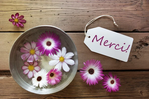 Zilveren kom met Cosmea Blossoms met tekst Merci — Stockfoto