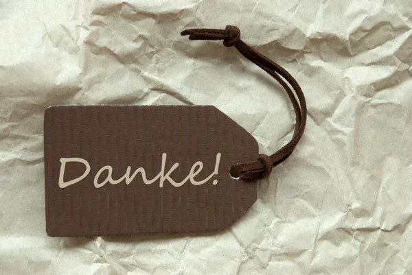 Hnědý štítek s německým Danke znamená Děkuji pozadím — Stock fotografie