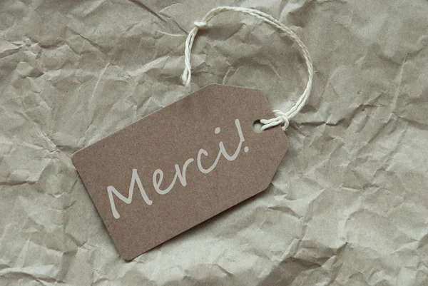 Beige Label met Franse Merci middelen dank u papier achtergrond — Stockfoto