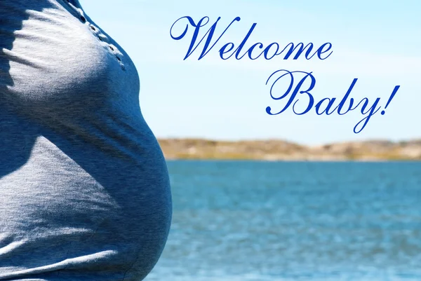 Donna incinta Fronte mare blu con testo Benvenuti Baby — Foto Stock