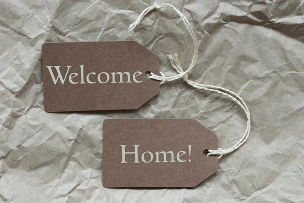 Eve hoşgeldin kağıt arka plan sahip iki kahverengi etiketi — Stok fotoğraf