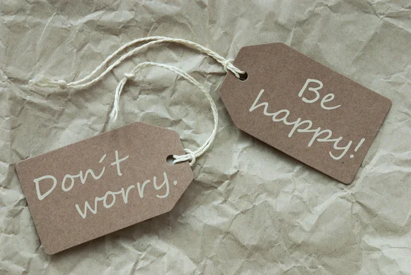 Zwei beige Etiketten mit Zitat Don 't worry happy paper background — Stockfoto