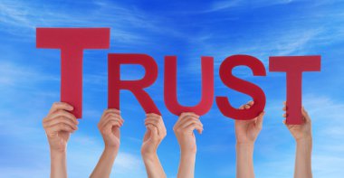 Pek çok kırmızı düz kelime tutan elleriyle mavi gökyüzü güven