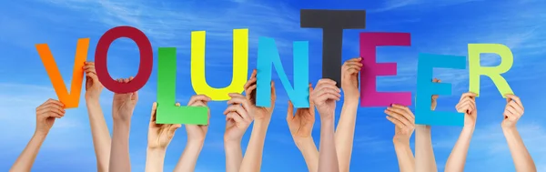 People Hands Holding Colorful Word Volunteer Blue Sky — Stock Photo, Image