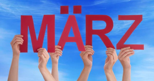 Las manos sostienen la palabra recta Maerz Mean March Blue Sky —  Fotos de Stock