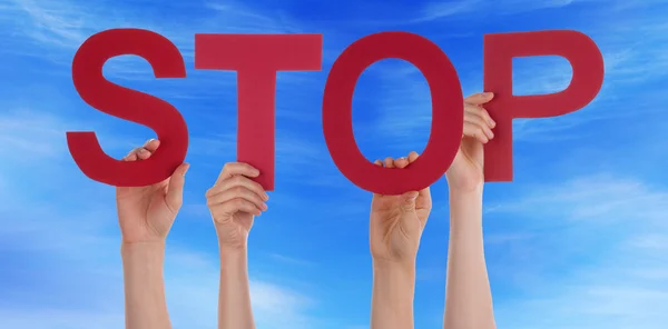 Manos sosteniendo la palabra recta roja Stop Blue Sky — Foto de Stock