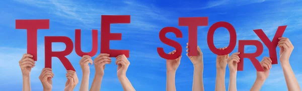 Las manos de la gente sosteniendo la palabra roja Historia verdadera Cielo azul — Foto de Stock