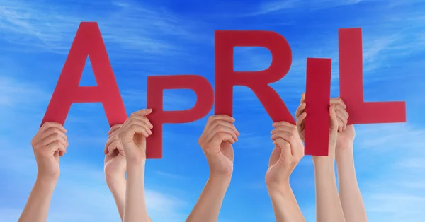 Molte persone mani in possesso di parola rossa aprile cielo blu — Foto Stock