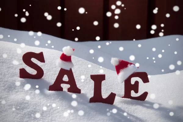 Natal venda flocos de neve Santa chapéu na neve — Fotografia de Stock