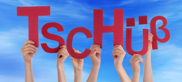 Persone in possesso di parola tedesca Tschuess significa ciao cielo blu — Foto Stock