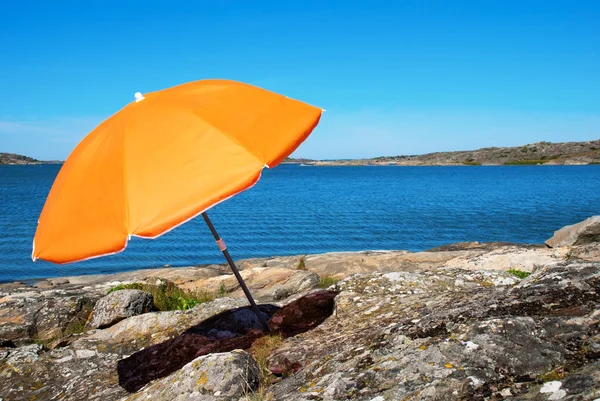 Шведское побережье с голубым морем и апельсиновым зонтиком — стоковое фото