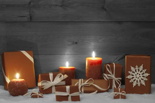 Decorazione natalizia con candele arancioni, regali e neve Foto Stock