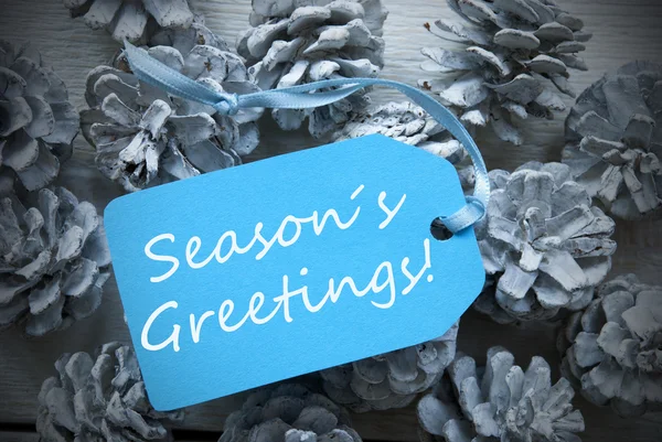 Light Blue Label On Fir Cones With Seasons Greetings — Stockfoto