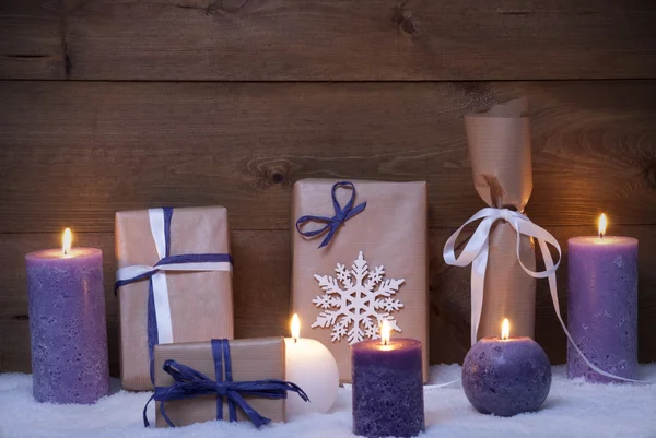 Regali di Natale viola con candele, neve Foto Stock