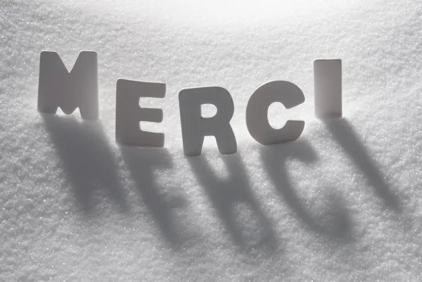 Weißes Wort merci bedeutet Danke auf Schnee — Stockfoto