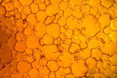 Petrol ve yağ çözücüden su kabarcıkları içeren soyut kırmızı ve sarı arkaplan makro fotoğrafçılığı kapat