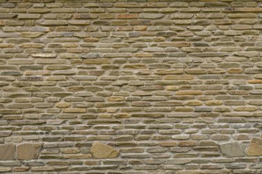 Duvardaki tuğlaların dokusunu vahşi taş arkaplan şeklinde. Gölgeli ve koyu renkli bej ve kahverengi tonlarda. Duvar arkaplanı için taşa bakıyor.