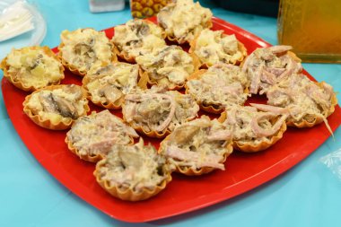 Şenlik masasında kırmızı tabakta atıştırmalık turtalar.