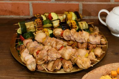 Tahta şişler üzerinde et şişleri ızgarada ızgara sebzelerin yanında yatıyor..