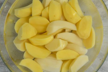 Suda dilimlenmiş çiğ patates. Üst Manzara. Gıda arkaplanı