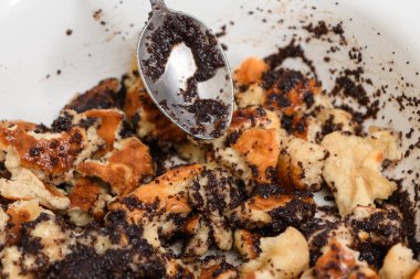 Haşhaş tohumlu gözlemeler pişirme işlemi. Haşhaş tohumlu tortilla kaşıkla karıştırılır.