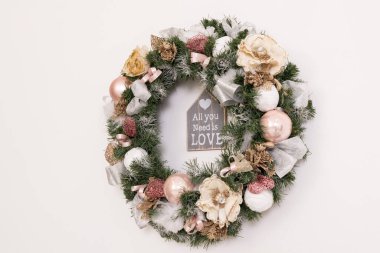 Duvarda bir Noel çelengi asılı.