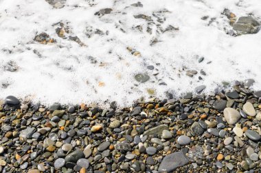 Çakıl taşı plajı. Deniz dalgaları kıyıya yakın..