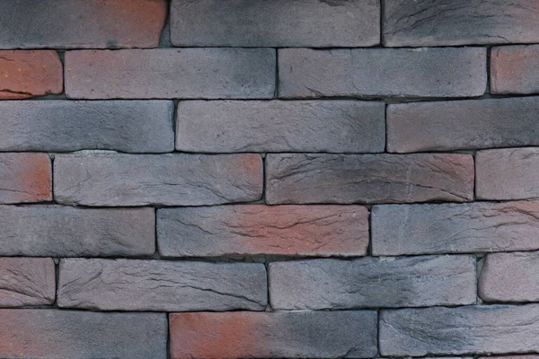 Brown, grey, black brick wall. Brickwork texture. Decorative wall decoration. Horizontal wallpaper. Stone background.