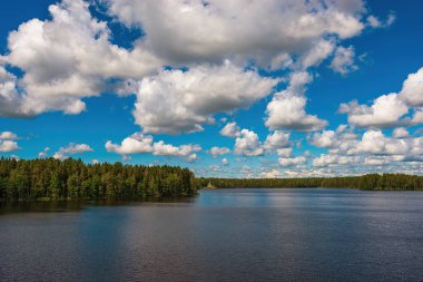 Güzel Roshchinsky Gölü 'nün üzerinde, manastırın duvarlarının yanında büyük kıvrımlı bulutlar. Leningrad bölgesindeki Kutsal Üçlü Alexander Svirsky Manastırı. XVI ve XVII yüzyıllarının mimari eserleriyle tanınıyor..