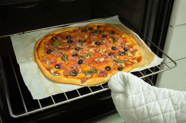 Taking the pizza from the oven — Stock Photo, Image