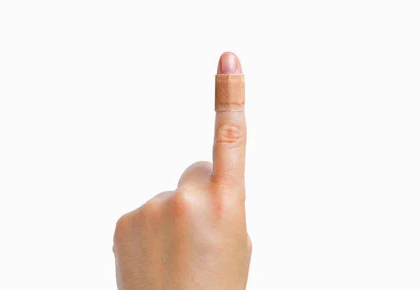一个女人的食指 手里拿着一条用白色隔离的创可贴 — 图库照片