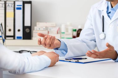 Muayene sırasında hastasına tavsiyeler veren bir doktorun görüntüsü.