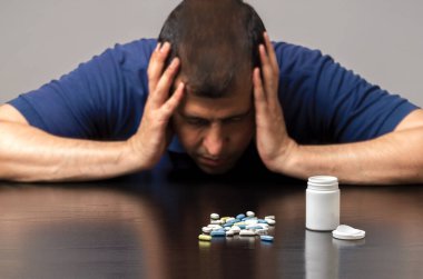 Uykusuzluk çeken bir adam uyku hapı alıyor.