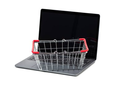 Laptop ve beyaz arka planda alışveriş sepeti metali. İnternet alışveriş kavramı