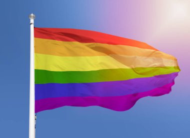 Gökyüzü arka planında rüzgarda dalgalanan gay bayrağının görüntüsü