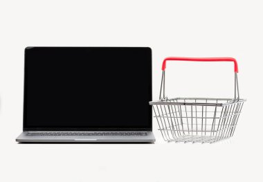 Laptop ve beyaz arka planda küçük alışveriş sepetleri. İnternet alışveriş kavramı