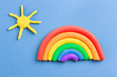 Plastik gökkuşağı ve güneş mavi arka planda