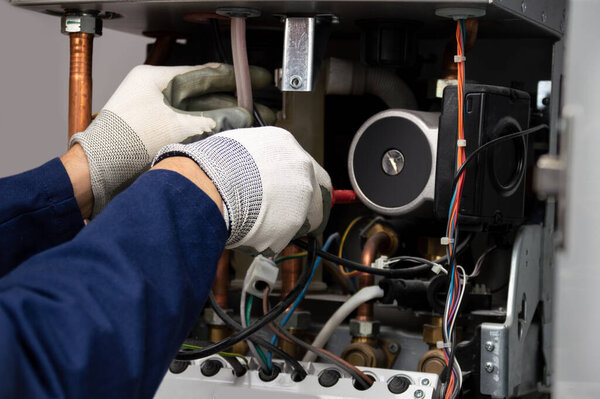 Cropped shot of an unrecognizable male boiler technician repairing a water pump stuck inside a house