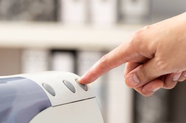 Tanımlanamayan bir adamın matbaa panelindeki düğmeye basılı görüntüsü. yazıcı tarayıcısı lazer ofis fotokopi makinesi malzemeleri kavramı başlat