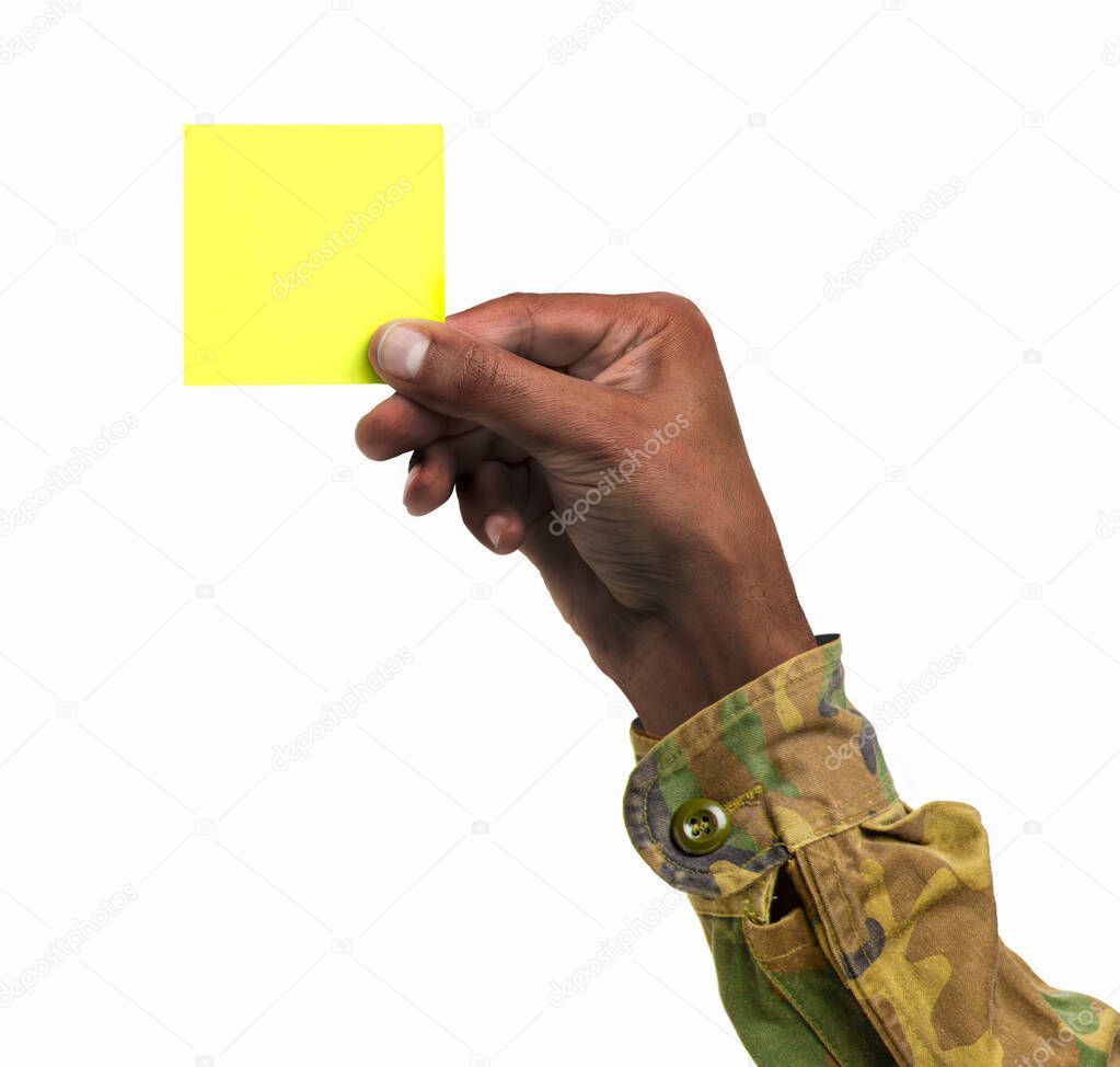 Cropped shot of an unrecognizable man hand with military clothing holding a yellow notepaper on a white isolated background