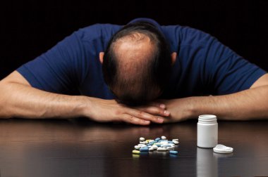 Kel bir adamın karanlık bir arka planda saç dökülmesini önlemek için hapların etkisizliği yüzünden depresyona girmesi.