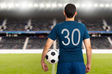 Paris 'te kollarının altında futbol topu tutan genç bir oyuncunun dikiz aynasından kesilmiş görüntüsü.