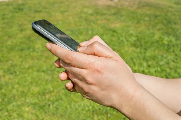 Usando su teléfono celular al aire libre — Foto de Stock