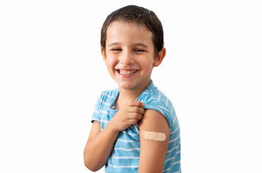 Portre, mutlu ve alçılı çocuk beyaz bir arka planda izole edildi. Yüzü, gülümsemesi ve çocuk aşıdan sonra bandajlı, yaralanmış ya da sağlık sigortası için yaralanmış, ilk yardım ve heyecan dolu